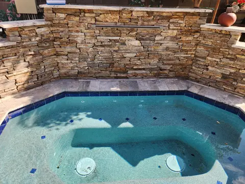 Pool with pebble-style finish and stone waterfall